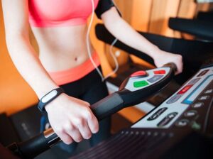 closeup-treadmill-used-by-young-sportswoman-with-fitness-tracker-her-hand 7 Advantages of Using a Running Watch